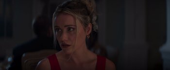 Movie still from “Born a Champion” (2021), directed by Alex Ranarivelo – A woman in a red dress looking at the camera; Close Up shot, Over the shoulder angle