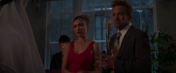 Movie still from “Born a Champion” (2021), directed by Alex Ranarivelo – A woman in a red dress and a man in a suit and tie; Medium shot, Over the shoulder angle