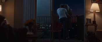Movie still from “Born a Champion” (2021), directed by Alex Ranarivelo – A man and a woman standing in front of a window; Wide shot, Low angle