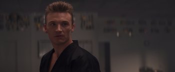 Movie still from “Born a Champion” (2021), directed by Alex Ranarivelo – A person wearing a black shirt; Close Up shot, Low angle