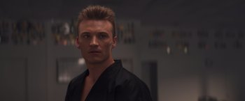 Movie still from “Born a Champion” (2021), directed by Alex Ranarivelo – A person wearing a black shirt; Close Up shot, Low angle