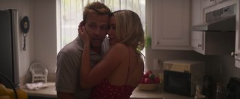 Movie still from “Born a Champion” (2021), directed by Alex Ranarivelo – A man and a woman embracing in a kitchen; Close Up shot, Low angle