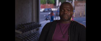 Movie still from “Born a Champion” (2021), directed by Alex Ranarivelo – A man with a beard and a purple t - shirt; Close Up shot, Over the shoulder angle