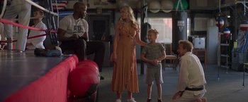 Movie still from “Born a Champion” (2021), directed by Alex Ranarivelo – A woman and a boy standing next to each other in a room; Wide shot, Over the shoulder angle