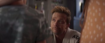 Movie still from “Born a Champion” (2021), directed by Alex Ranarivelo – A person wearing a white shirt; Close Up shot, Over the shoulder angle