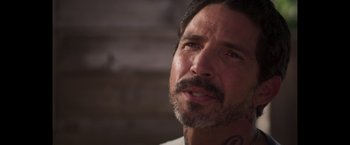 Movie still from “Born a Champion” (2021), directed by Alex Ranarivelo – A person with a tattoo on his neck; Close Up shot, Over the shoulder angle