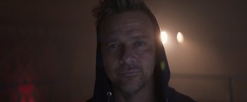 Movie still from “Born a Champion” (2021), directed by Alex Ranarivelo – A person wearing a hooded sweatshirt; Close Up shot, Low angle