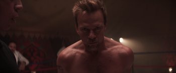 Movie still from “Born a Champion” (2021), directed by Alex Ranarivelo – A man with a beard is looking at the camera; Close Up shot, Low angle