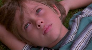 Movie still from “Boyhood” (2014), directed by Richard Linklater – A child laying in the grass; Close Up shot, Overhead angle