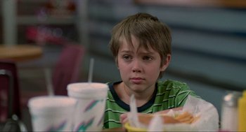 Movie still from “Boyhood” (2014), directed by Richard Linklater – A young boy sitting at a table with food in front of him; Close Up shot, Low angle