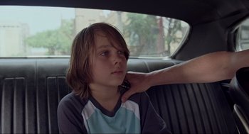 Movie still from “Boyhood” (2014), directed by Richard Linklater – A young boy sitting in the back seat of a car; Close Up shot, Over the shoulder angle