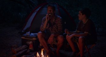 Movie still from “Boyhood” (2014), directed by Richard Linklater – A man and a woman sitting in front of a campfire; Medium shot, Over the shoulder angle