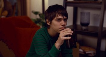Movie still from “Boyhood” (2014), directed by Richard Linklater – A young man drinking a glass of beer; Close Up shot, Over the shoulder angle