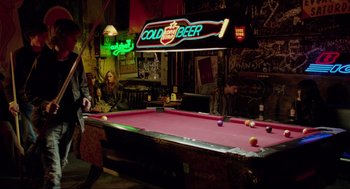 Movie still from “Boyhood” (2014), directed by Richard Linklater – A pool table in a room with a neon sign above it; Wide shot, Over the shoulder angle