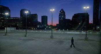 Movie still from “Boyhood” (2014), directed by Richard Linklater – A person is walking in a parking lot at night; Extreme Wide shot, High angle