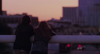 Movie still from “Boyhood” (2014), directed by Richard Linklater – Two people sitting on a railing watching the sunset; Wide shot, Over the shoulder angle