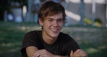Movie still from “Boyhood” (2014), directed by Richard Linklater – A young man smiling while sitting on the grass; Close Up shot, Low angle