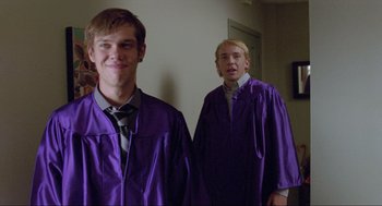 Movie still from “Boyhood” (2014), directed by Richard Linklater – Two young men in graduation robes standing next to each other; Medium shot, Over the shoulder angle