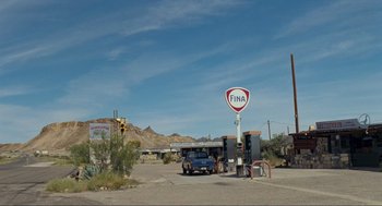 Movie still from “Boyhood” (2014), directed by Richard Linklater – An old car is parked at a gas station; Extreme Wide shot, High angle