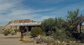 Movie still from “Boyhood” (2014), directed by Richard Linklater – A man standing in front of an old store in the desert; Extreme Wide shot, Low angle