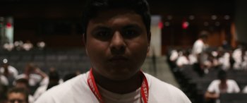 Movie still from “Boys State” (2020), directed by Amanda McBaine – A person wearing a neck band; Close Up shot, Low angle