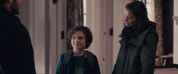 Movie still from “Brahms: The Boy II” (2020), directed by William Brent Bell – A young boy wearing a green shirt and a black jacket; Medium shot, Over the shoulder angle