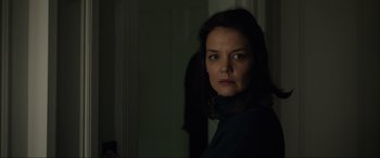 Movie still from “Brahms: The Boy II” (2020), directed by William Brent Bell – A woman standing in a dark room looking at the camera; Close Up shot, Over the shoulder angle