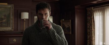Movie still from “Brahms: The Boy II” (2020), directed by William Brent Bell – A man drinking a cup of coffee while wearing a sweater; Close Up shot, Over the shoulder angle