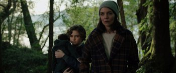 Movie still from “Brahms: The Boy II” (2020), directed by William Brent Bell – A woman and a child are standing in the woods; Medium shot, Over the shoulder angle