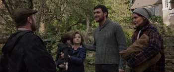 Movie still from “Brahms: The Boy II” (2020), directed by William Brent Bell – A man and a woman and a child standing next to each other in front of trees; Medium shot, Over the shoulder angle