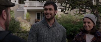 Movie still from “Brahms: The Boy II” (2020), directed by William Brent Bell – A man wearing a sweater smiling for the camera; Close Up shot, Over the shoulder angle