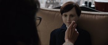 Movie still from “Brahms: The Boy II” (2020), directed by William Brent Bell – A woman is putting makeup on a doll face; Close Up shot, Over the shoulder angle