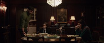 Movie still from “Brahms: The Boy II” (2020), directed by William Brent Bell – Two young boys sitting at a dinner table in suits; Medium shot, Over the shoulder angle