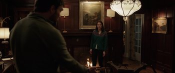 Movie still from “Brahms: The Boy II” (2020), directed by William Brent Bell – A man and a woman standing in front of a fireplace; Medium shot, Over the shoulder angle