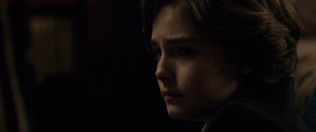 Movie still from “Brahms: The Boy II” (2020), directed by William Brent Bell – A young boy is looking into the distance; Close Up shot, Over the shoulder angle