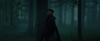 Movie still from “Brahms: The Boy II” (2020), directed by William Brent Bell – A man standing in the middle of a forest; Medium shot, Low angle