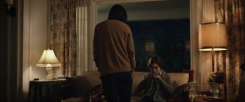 Movie still from “Brahms: The Boy II” (2020), directed by William Brent Bell – A woman standing in front of another woman smoking a cigarette; Medium shot, Over the shoulder angle