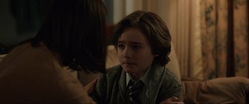 Movie still from “Brahms: The Boy II” (2020), directed by William Brent Bell – A young boy sitting in front of a woman; Close Up shot, Over the shoulder angle