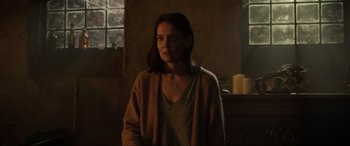 Movie still from “Brahms: The Boy II” (2020), directed by William Brent Bell – A woman standing in front of a window in a room; Medium shot, Over the shoulder angle