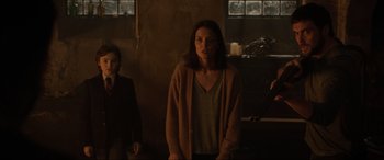 Movie still from “Brahms: The Boy II” (2020), directed by William Brent Bell – A woman standing in front of another woman in a dark room; Medium shot, Over the shoulder angle