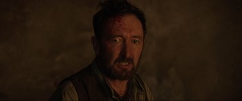 Movie still from “Brahms: The Boy II” (2020), directed by William Brent Bell – A person wearing a vest with a face covered in blood; Close Up shot, Over the shoulder angle