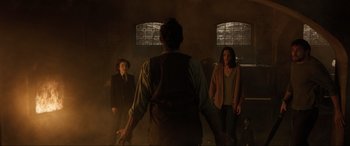 Movie still from “Brahms: The Boy II” (2020), directed by William Brent Bell – A group of people standing in a dimly - lit room; Wide shot, Low angle