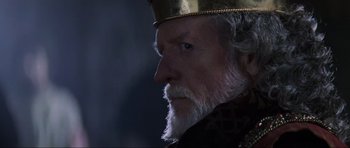 Movie still from “Braveheart” (1995), directed by Mel Gibson – An old man with a beard wearing a gold crown; Close Up shot, Over the shoulder angle