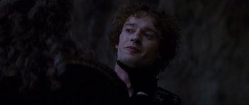 Movie still from “Braveheart” (1995), directed by Mel Gibson – A person with curly hair wearing a suit; Close Up shot, Over the shoulder angle