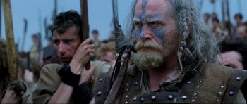 Movie still from “Braveheart” (1995), directed by Mel Gibson – An old man with a beard and blue face paint; Close Up shot, Low angle