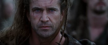 Movie still from “Braveheart” (1995), directed by Mel Gibson – A person with a beard and blue eyes; Close Up shot, Low angle