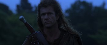 Movie still from “Braveheart” (1995), directed by Mel Gibson – A person with long hair holding a sword; Close Up shot, Low angle