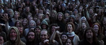 Movie still from “Braveheart” (1995), directed by Mel Gibson – A large group of people wearing hoods and smiling for the camera; Wide shot, High angle