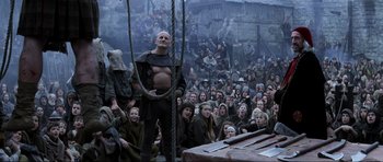 Movie still from “Braveheart” (1995), directed by Mel Gibson – A group of people gathered around a man on a rope; Wide shot, Low angle