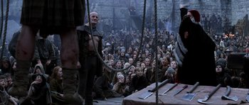 Movie still from “Braveheart” (1995), directed by Mel Gibson – A group of people sitting in a room with ropes; Wide shot, Low angle